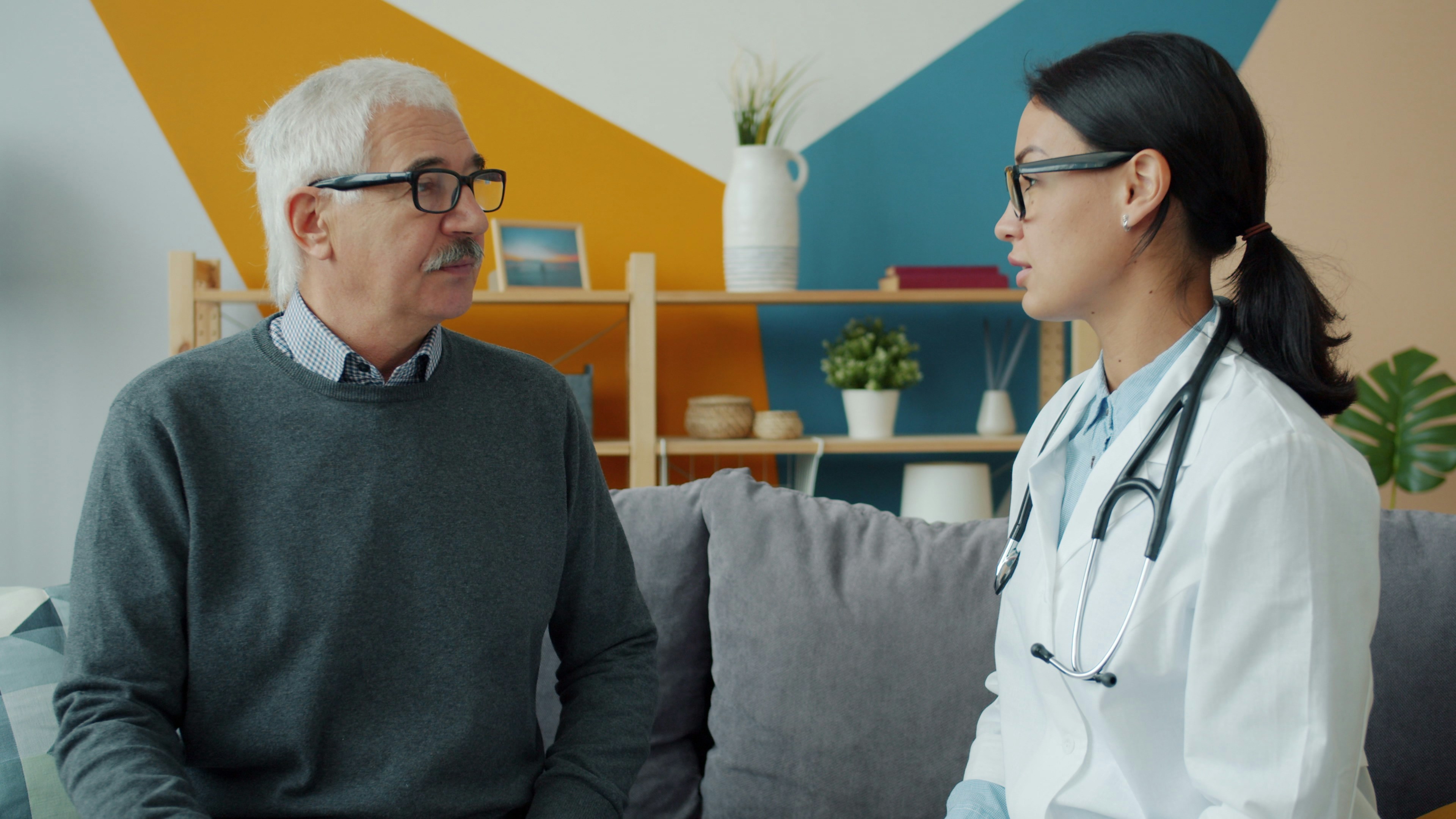 A nurse talking with an elderly patient at home